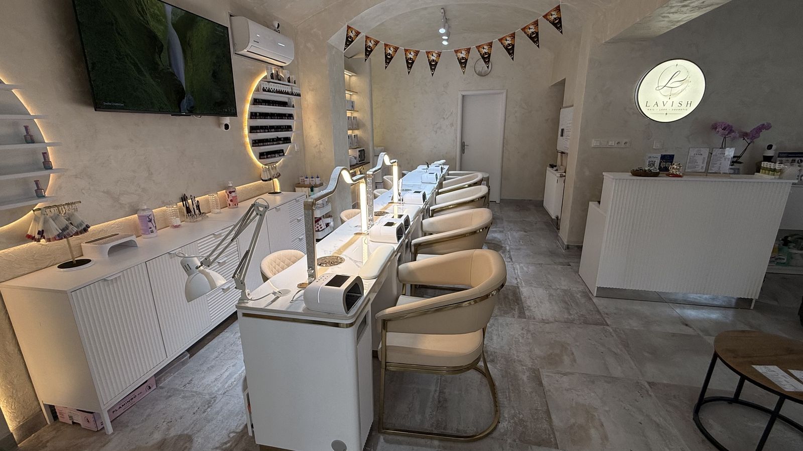 Recepce a manikúrní stoly, na stěně zlaté logo Lavish